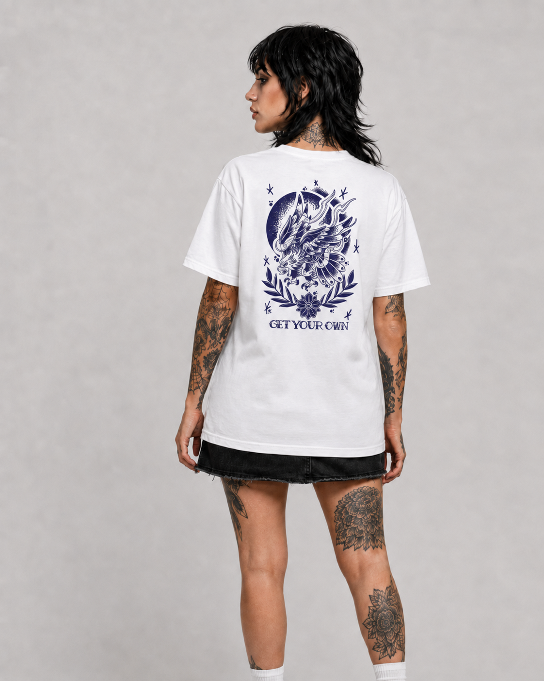 Female model wearing the Old School Eagle Graphic Tee in white with blue back print