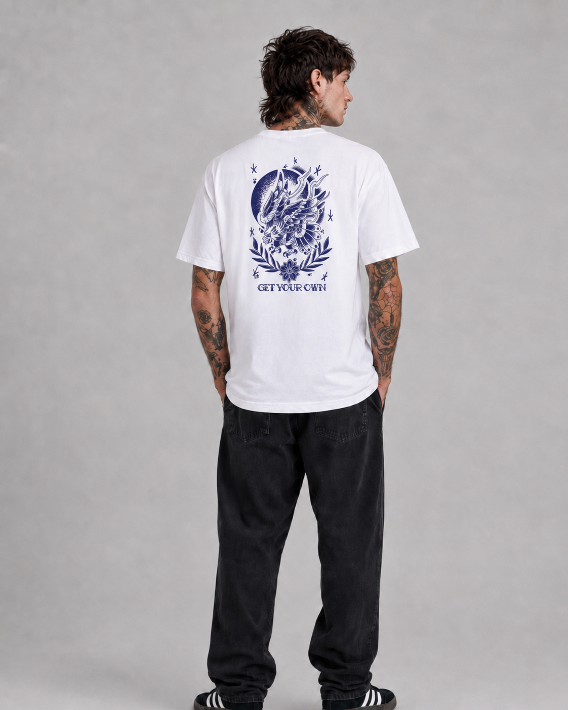 Male model wearing the Old School Eagle Graphic Tee in white with blue back print