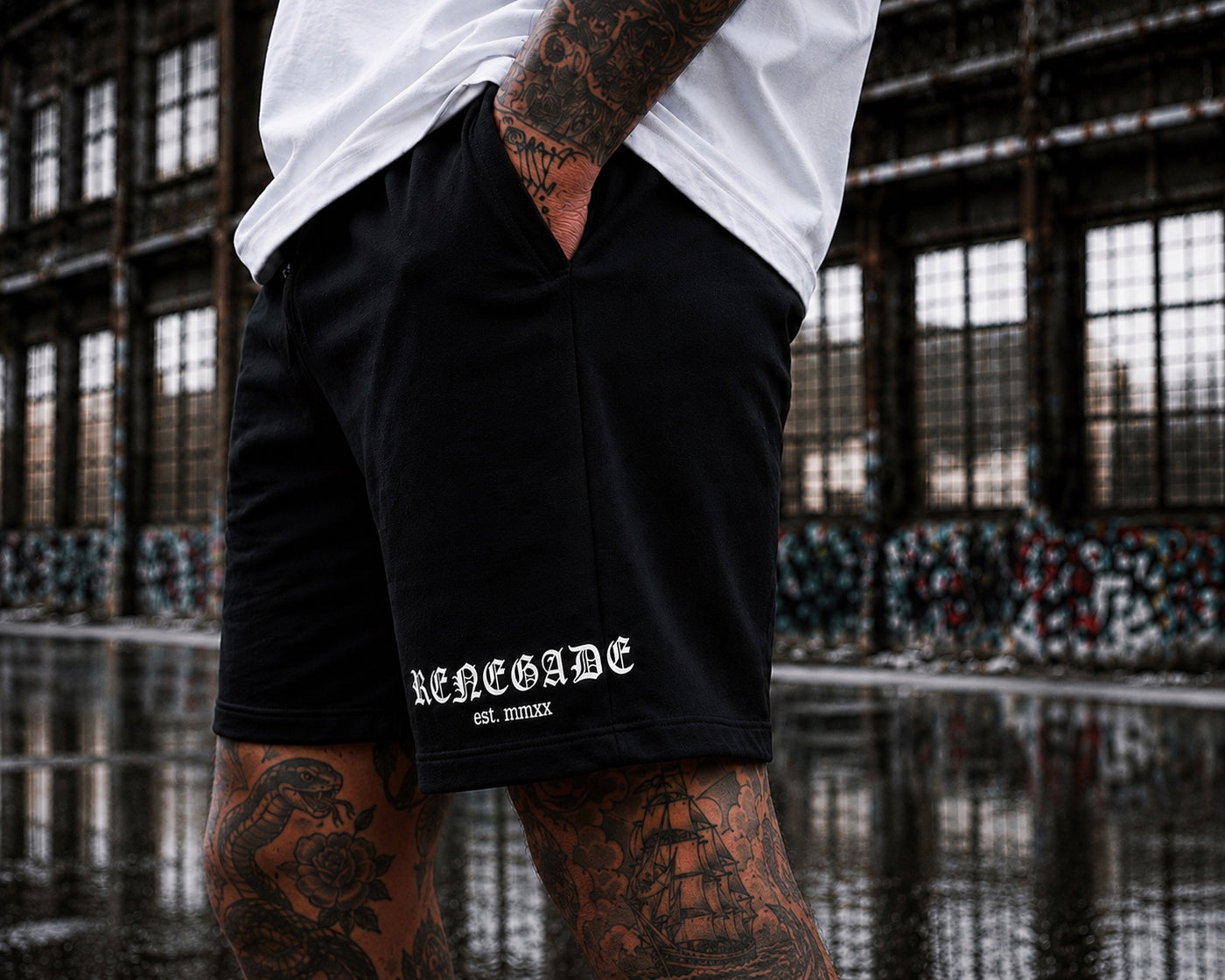 Close-up of white Original Renegade DTF leg print on black heavyweight shorts