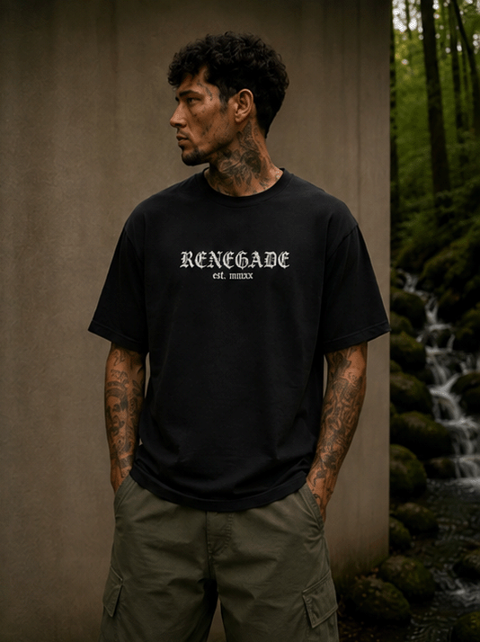 Male model wearing black Renegade gothic logo T-shirt beside a woodland stream