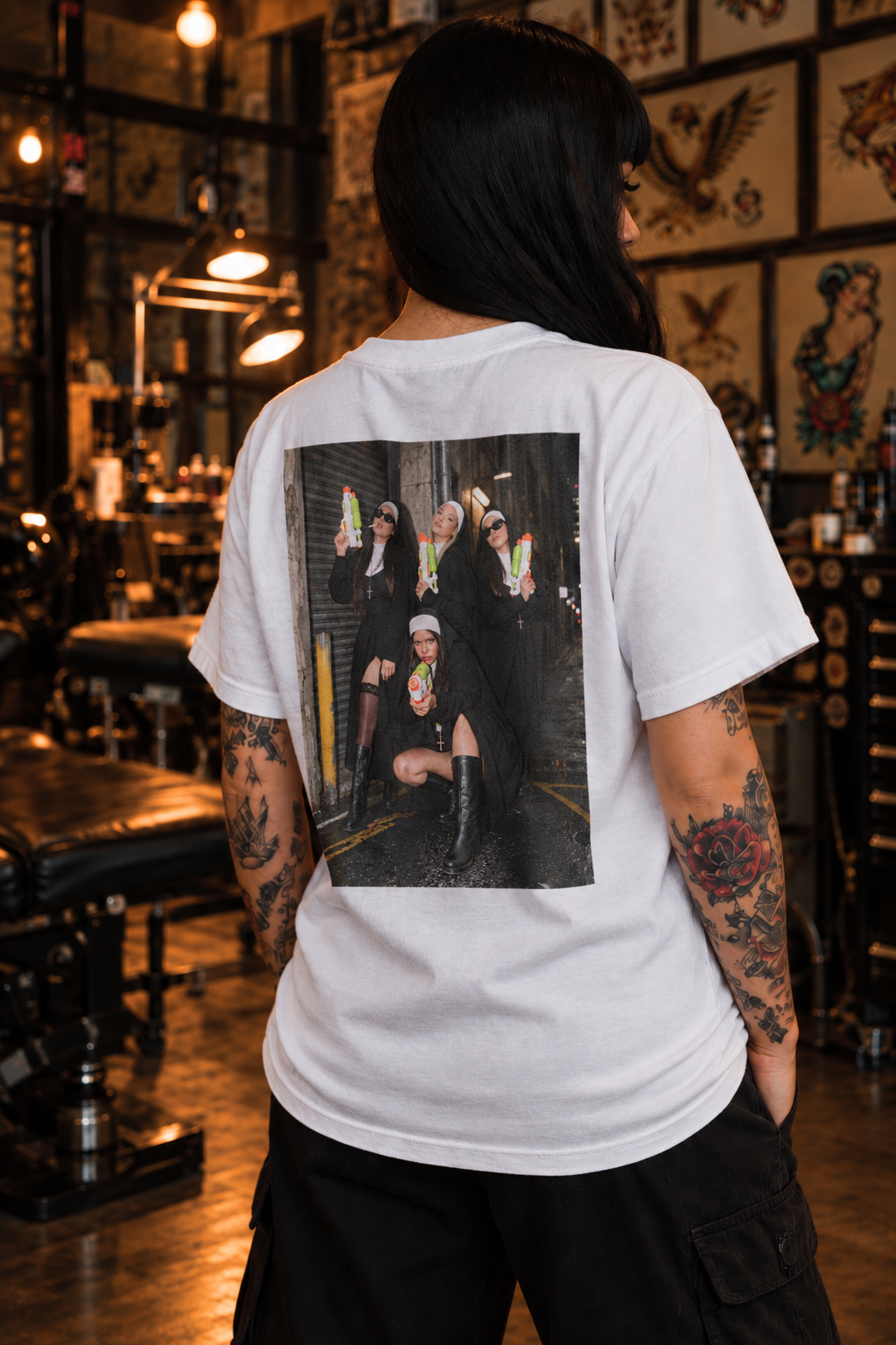 Super Sinner white graphic tee on tattooed female model, alternate rear angle